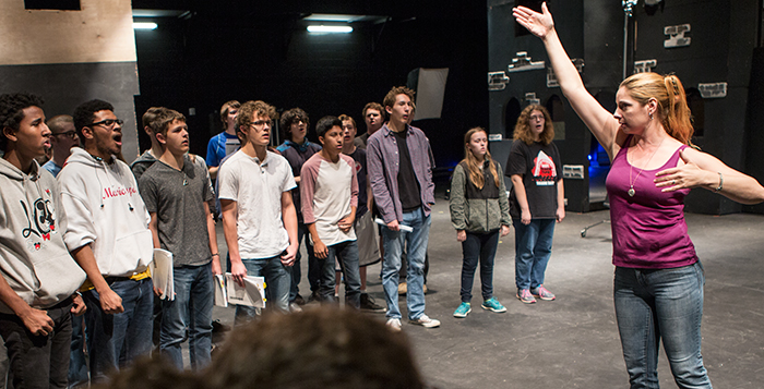 Teacher Cynthia Calhoun directs the huge cast in the musical version of “Les Miserables.” Photo by Jake Johnson