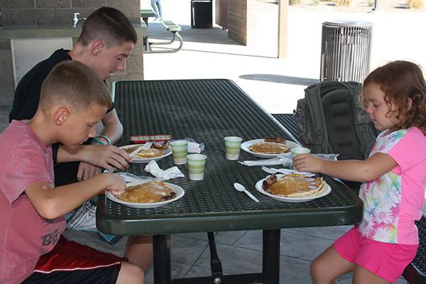 From left, Easton, Zachary and Talyor Schroeder enjoy the American Legion's pancake breakfast during the Pokemon event at Copper Sky. Photo by Raquel Hendrickson