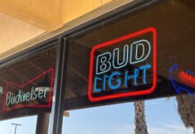 Neon Budweiser signs hang in the window of Raceway Bar and Grill. Owners felt effects of the Bud Light boycott at their Papago Road bar. [Elias Weiss]