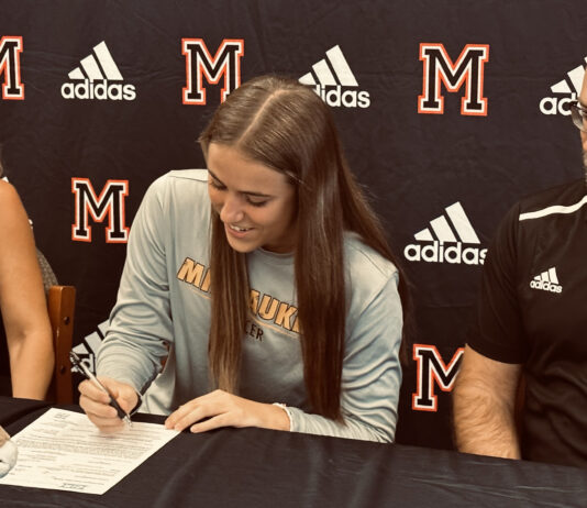 With parents Chani and Jason looking on, Maricopa High School's Abby Kuehnl signs her letter of intent to play DI soccer at UW-Milwaukee. [Jeff Chew]