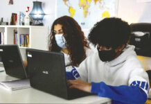 A pair of students work on laptops while wearing masks in a classroom at A+ Charter School. [Courtesy of A+ Charter Schools]