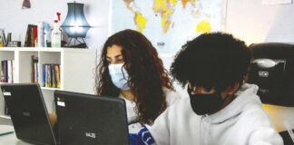 A pair of students work on laptops while wearing masks in a classroom at A+ Charter School. [Courtesy of A+ Charter Schools]