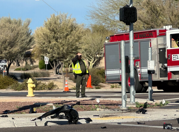 A law enforcement officer stands near the intersection of John Wayne and Alterra parkways during an investigation into a crash that killed a motorcyclist on Feb. 1, 2024. Pinal County Sheriff's Office identified the motorcyclist as Demetrius Catus, 29.