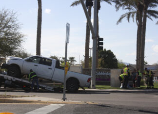 A tow truck begins to haul away a pickup truck involved in a two-vehicle crash on John Wayne Parkway and Cobblestone Farms Drive on March 13, 2024. First responders were seen attending to crash victims, including three children. [Jeff Chew]
