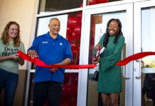 Maricopa Chamber of Commerce Director Kelly Anderson and Councilmember Henry Wade smile as LaQuinta Fisher cuts the ribbon in front of her new salon, Silk Press Xpress, on April 6, 2024. [Monica D. Spencer]