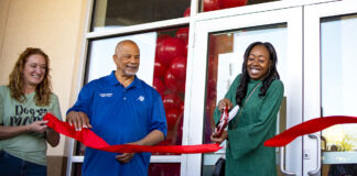 Maricopa Chamber of Commerce Director Kelly Anderson and Councilmember Henry Wade smile as LaQuinta Fisher cuts the ribbon in front of her new salon, Silk Press Xpress, on April 6, 2024. [Monica D. Spencer]