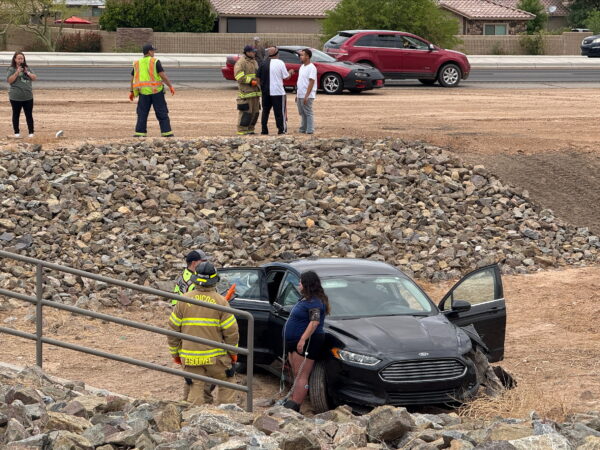 A woman is rated by firefighters after her black Ford fusion came into a ditch in front of John Wayne Parkway. May 6, 2025. [Brian Petersheim Jr.]
